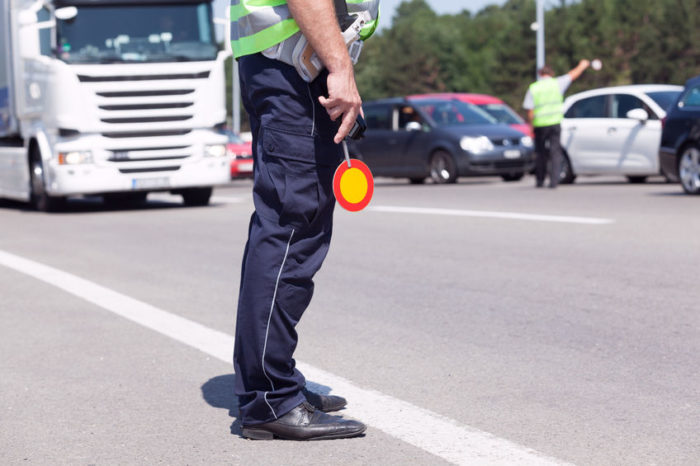 Politimand med stopskilt fartskriver